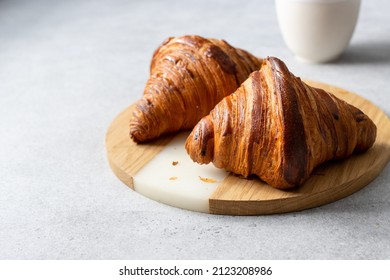 Two Croissants On The Wooden Desk. White Background. Early Morning Breakfast.