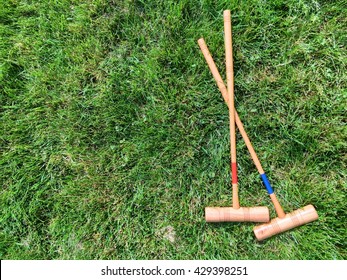 Two Croquet Mallets On Grass Background