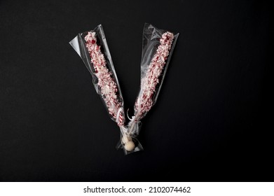 Two Crushed Candy Cane Sticks Isolated In The Black Background