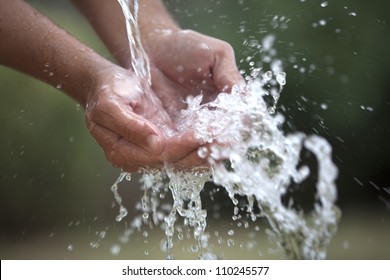 Two Cupped Hands Feel The Water Spashing Into Them Gently.