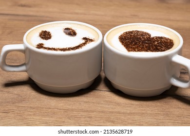 Two Cups Of Cappuccino With Trendy Heart And Latte Art Smile. Coffee For A Couple In Love