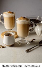 Two cups with coffee drink, latte or mocha with milk foam and cinnamon