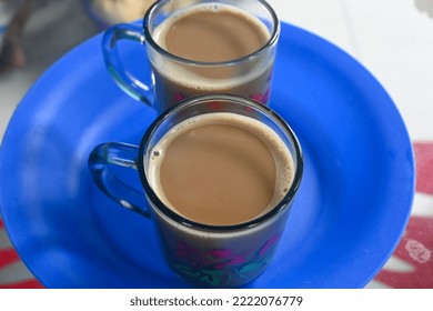 Two Cups Of Coffee Served On A Blue Plastic Plate.