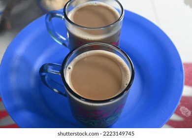 Two Cups Of Coffee Served On A Blue Plastic Plate.