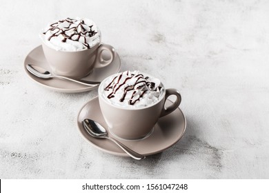 Two Cups Of Coffee With Whipped Cream And Chocolate Topping. Iced Coffee In White Cup Isolated On Bright Marble Background. Overhead View, Copy Space. Advertising For Cafe Menu. Coffee Shop Menu