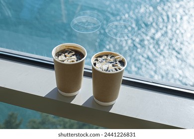 Two cups of coffee at window overlooking the sea