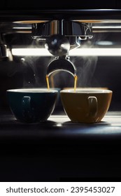Two cups of espresso brewing side by side, highlighted by a strong backlight. - Shutterstock ID 2395453027