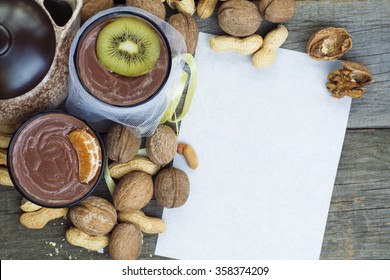 Two Cups Of Healthy Vegan Chocolate Pudding With Walnuts, Peanuts, Fruit. Romantic Date. Valentine's Day. Red Heart Paper For Message. Toned Image