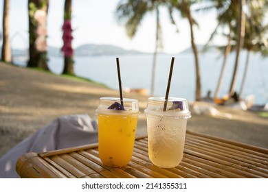 Two cups Orange juice on top table seaside during sunset sky daylight. Close-up Fresh orange cocktail in glass cafe holiday coconut trees background. Water drink summer copy space 2022. no people - Shutterstock ID 2141355311