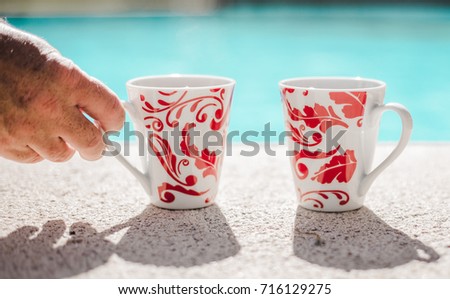 Two cups of tea by the pool side for British holiday makers