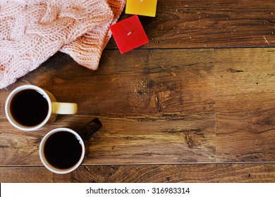 Two Cups Of Tea Or Coffee, Candles And Knitted Warm Scarf On Wooden Table. Flat Lay Winter And Autumn Cozy Vintage Background With Copy Space.