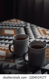 Two cups of tea on a table inside the wooden house