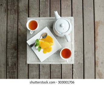 Two Cups Of Tea With Teapot And A Piece Of Mango Cake, Top View