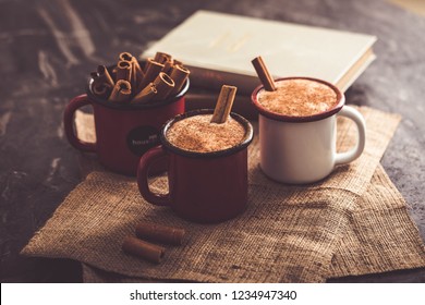 Two cups of Turkish salep (milky traditional hot drink) with cinnamon sticks on sack fabric