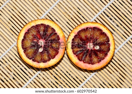Two cut red orange on a bamboo napkin close-up
