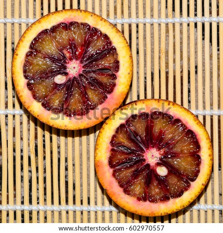 Two cut red orange on a bamboo napkin close-up