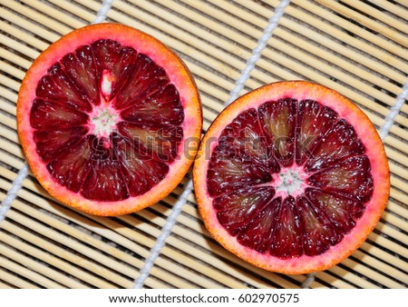 Two cut red orange on a bamboo napkin close-up