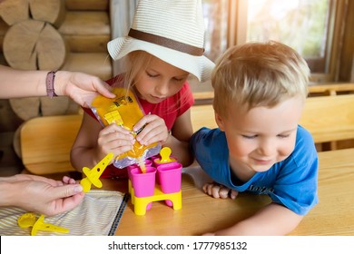 Two Cute Adorable Caucasian Blond Little Sibling Sitting At Table Home Yard And Have Fun Making With Mom Homemade Fruit Icecream. Young Happy Children Enjoy Cooking With Mother Outside. Family Love