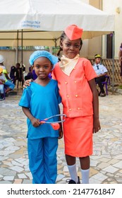 Two Cute African Girls Or Students In Air Hostess And Medical Outfit Standing Together Outdoor In A School Gathering As They Celebrate Career Day