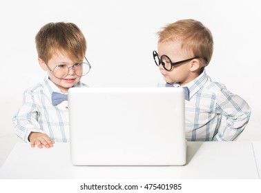 Two cute baby with laptop isolated in studio.