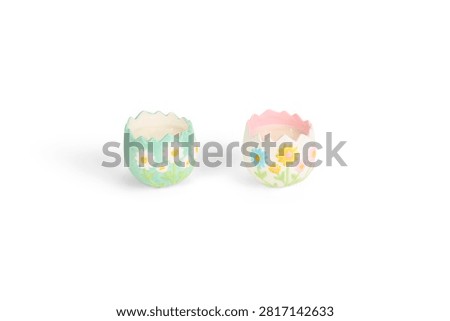 Two cute ceramic egg shell shaped candles decorated with hand painted daisy flowers, perfect for Easter and spring home decoration themes.