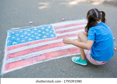 Two Cute Friends Girls Drawing American Flag With Colored Chalks On The Sidewalk Near The House On Sunny Summer Day. Kids Painting Outside. Creative Development Of Children. Patriotic Day Concept