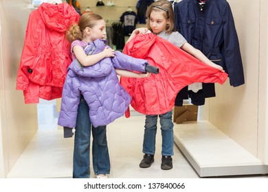 Two Cute Girls Try On Clothes In A Modern Store Childrens Clothes