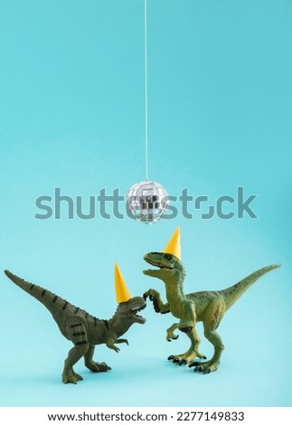 Two cute green dinosaurs dancing under disco ball. Funny idea for birthday card on blue background.