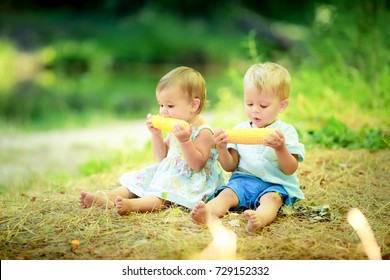 Two Cute Kids In The Woods Eating Corn