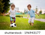 Two cute little boys, playing football