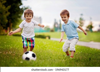 Two cute little boys, playing football