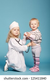 two cute little girls playing doctor. studio photo