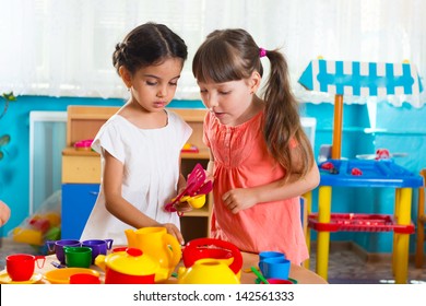 Two cute little girls playing role game in daycare