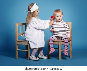 two cute little girls playing doctor