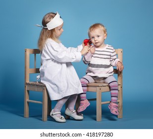 two cute little girls playing doctor