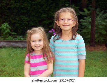 Two Cute Little Girls Smiling In The Backyard, Height Difference       