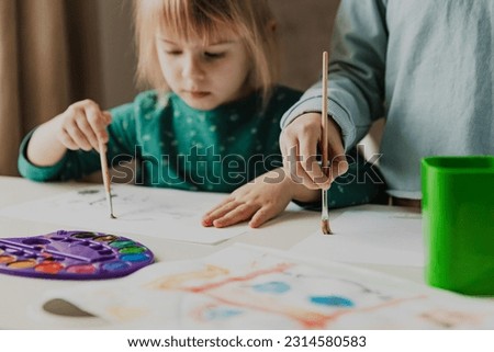 Two cute little sisters, classmates are painting on table. Small girl kids with brush in school. Happy adorable preschooler, 4 and 7 years child in living room. Home schooling concept, doing homework Stock photo © 