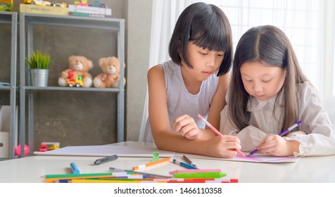 Two Cute Little Sisters Writing Letters Together At Home. Older Sister Helping Youngster With Her Homework. Education For Kids