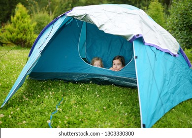 Two cute young sisters playing in a tent on a campsite. Active lifestyle, family recreational weekend, summer outdoor. Family time. - Shutterstock ID 1303330300