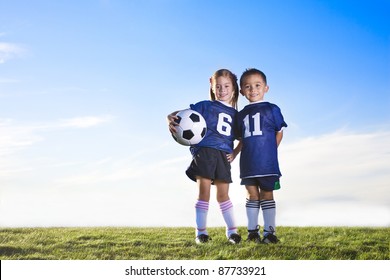 Two cute youth soccer players wearing their team uniforms
