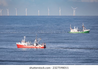 Two cutters passing each other in the North sea with wind turbines of a windfarm in the background - Powered by Shutterstock