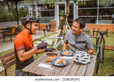 two cyclist enjoying coffee in the cafe after riding - Powered by Shutterstock