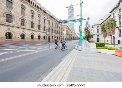 Two Cyclists Enter The Bike Path Of Eje Central Lázaro Cárdenas Avenue With Tower Latino Building In Downtown Mexico City, CDMX, Mexico