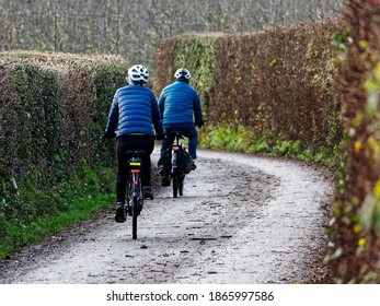 Two cyclists on electric bikes on a narrow rural lane in the UK. - Powered by Shutterstock