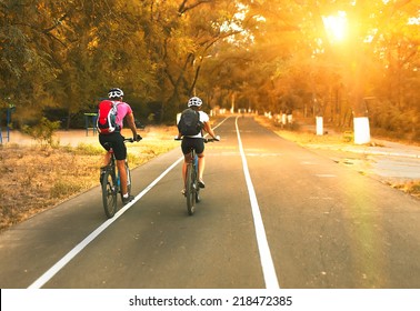 Two Cyclists Riding On Road 