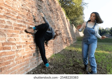 Two dancers performing a modern choreography in an urban setting with an old brick wall - Powered by Shutterstock