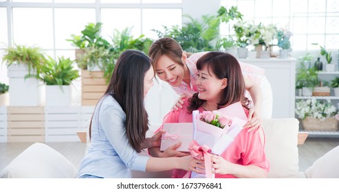 two daughters give flowers to her mom and celebrate happy mother day at home - Powered by Shutterstock