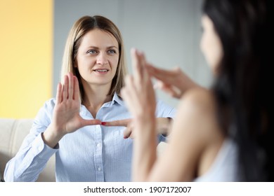 Two deaf and dumb women talking gestures at home. Hearing loss disability person lifestyle concept