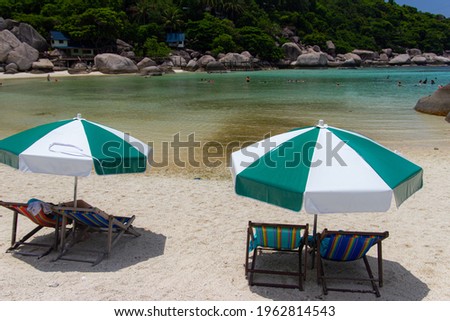 Two deckchairs and umbrellas on the Beach.
