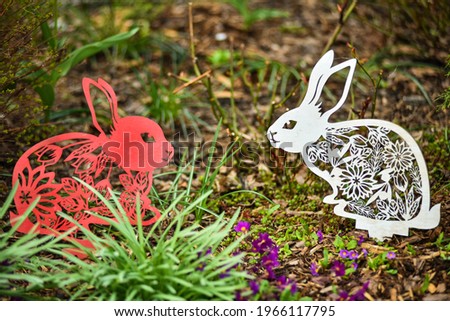 Two decorative hares are sitting in the garden
